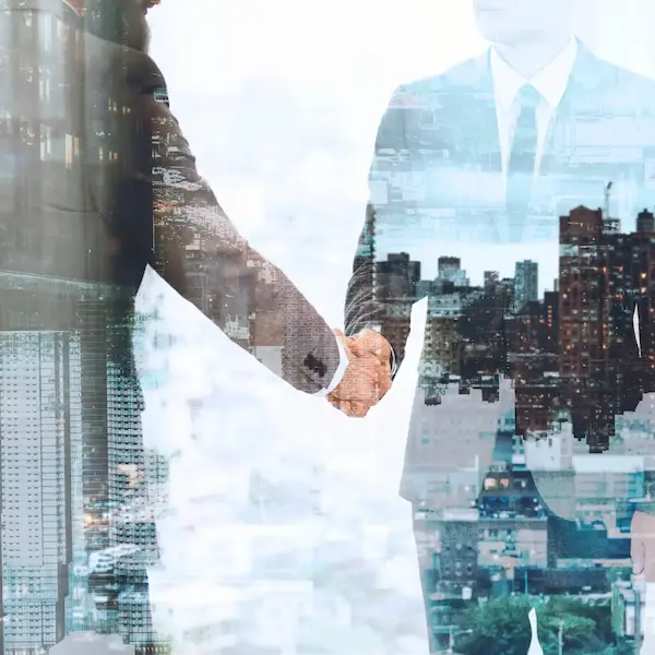 Two business professionals shaking hands — a symbol of trusted partnership.